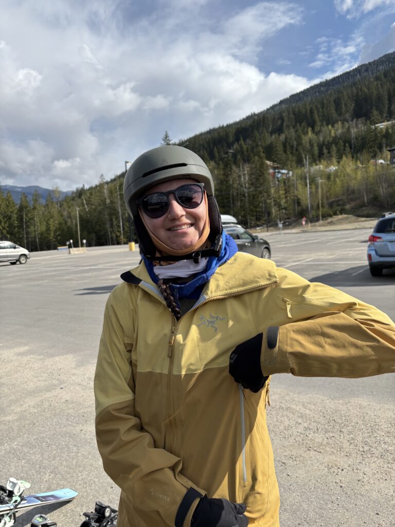 Azul-Sky zipping up a ski jacket while smiling at the camera