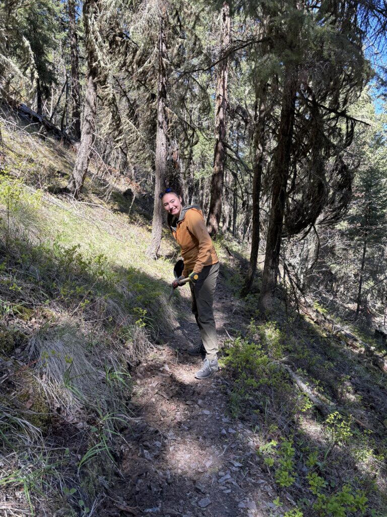 Azul-Sky holding a pic-axe helping maintain mountain biking trails